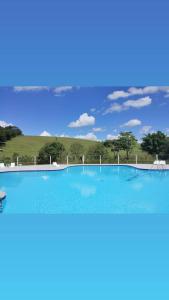 阿瓜斯迪林多亚Pousada Vida feliz的一座大型蓝色游泳池,后面有一座小山