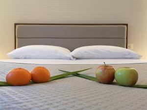 皮亚扎-阿尔梅里纳Panorama Suite的床上有两只橙子和两只苹果