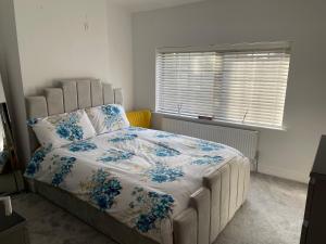 曼彻斯特Warm welcoming Home的一间卧室配有一张带蓝色鲜花的大床