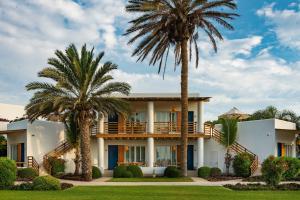 帕拉卡斯Hotel Paracas, a Luxury Collection Resort, Paracas的前面有棕榈树的房子