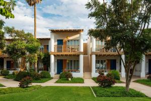 帕拉卡斯Hotel Paracas, a Luxury Collection Resort, Paracas的享有棕榈树建筑的外部景色