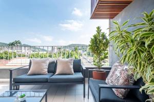 里约热内卢Jacarepaguá Residence - Quarto em apartamento的阳台的天井配有沙发和植物