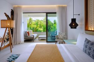 马埃岛laïla, Seychelles, a Marriott Tribute Portfolio Resort的一间卧室设有一张床和一间客厅。