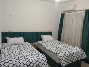 沙姆沙伊赫2 Bedroom Apartment with pool view的两张睡床彼此相邻,位于一个房间里