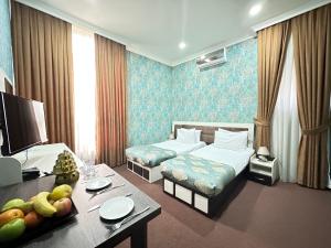 巴库Istanbul Gold Hotel的酒店客房,配有床和一张带水果的桌子
