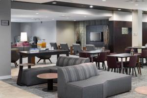 奥斯汀奥斯丁北/帕默大道万怡酒店的大堂设有桌椅和电视。