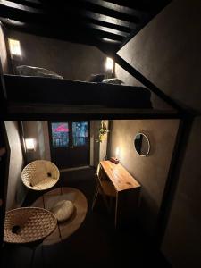 墨西哥城Casa Sabina Down Town Mexico City的一间客房配有两把椅子、一张桌子和一张双层床。