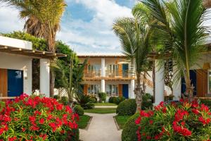 帕拉卡斯Hotel Paracas, a Luxury Collection Resort, Paracas的别墅,种植了棕榈树和红花