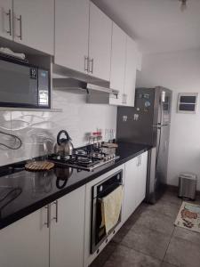 利马Apartment 4 Rent - Av. San Borja Norte Cdra 7的厨房配有白色橱柜和炉灶烤箱。