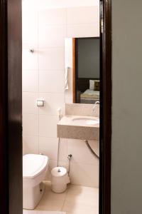 巴乌鲁Alliance Hotel的一间带卫生间、水槽和镜子的浴室