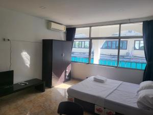 芭堤雅市中心THE NEST的一间卧室设有一张床和一个大窗户