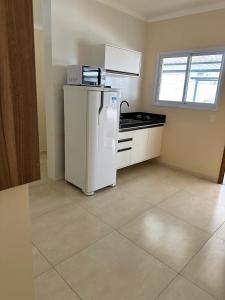 皮拉西卡巴KITNET 1001 Apart Hotel的厨房配有白色冰箱和窗户。