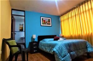 万卡约Hostal Los Pinos的蓝色卧室,配有床和椅子