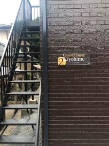 田边市Guest House Kiyohime的砖楼一侧有标志的楼梯