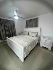 圣地亚哥洛斯卡巴Residencial joyas d’ luxe lll的卧室配有白色的床和白色梳妆台