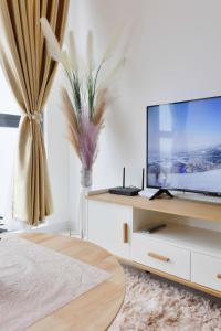 哥打巴鲁Sofea Suites @ Troika Kota Bharu #Wifi #Netflix的客厅配有壁橱上的平面电视