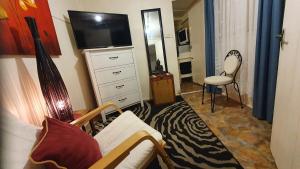 墨尔本Adorabe 1-Bedroom guesthouse with free parking on premises的客厅配有床、电视和椅子
