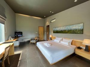 外南梦Teras Hotel Ijen Banyuwangi的卧室配有一张白色大床和一张书桌