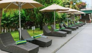 棉兰埃默拉尔德花园国际酒店的度假村的一排椅子和遮阳伞