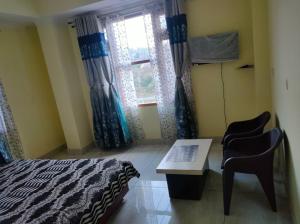 马恩迪Mahamaya Homestay 4的一间卧室配有一张床、一张书桌和一个窗户。