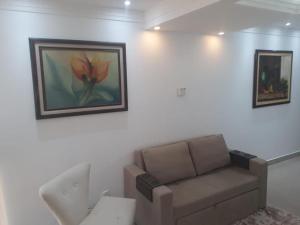 巴西利亚Unidade Executiva Luxo 33m²的客厅配有沙发和墙上的绘画