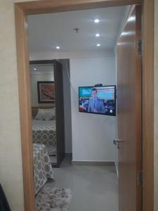 巴西利亚Unidade Executiva Luxo 33m²的一间配有电视的壁挂式客房,配有一张床