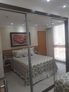 巴西利亚Unidade Executiva Luxo 33m²的一间卧室配有一张床和一面大镜子