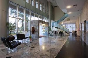 巴西利亚Unidade Executiva Luxo 33m²的大厅,设有椅子和楼梯,位于大楼内