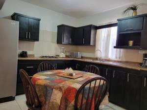 奇瓦瓦Departamento UNIVERSITARIO en fraccionamiento privado的一间带桌椅的厨房和一间带黑色橱柜的厨房