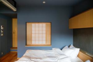 仓敷Temari Inn Madoromi的蓝色卧室,配有一张带窗户的床