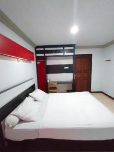 美娜多Hotel Riverside Manado的卧室配有一张白色大床