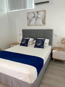 UranganMarlin Villa - Hervey Bay的一间卧室配有一张带蓝白色枕头的大床