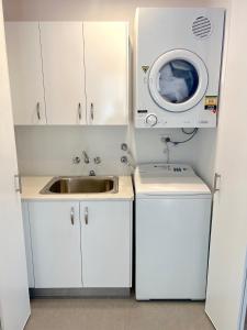 UranganMarlin Villa - Hervey Bay的厨房配有水槽和洗衣机