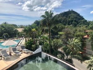 奥南海滩Ao Nang Colors Hotel - Aonang Beach的设有一个游泳池的度假村阳台,享有风景