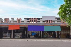 邦加槟港SPOT ON 92421 City Kost Syariah的前面有五颜六色标志的建筑