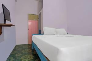 邦加槟港SPOT ON 92421 City Kost Syariah的红色门的房间的一张白色的床
