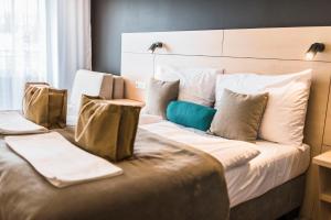 卡鲁扎Hotel Thermal ŠÍRAVA的酒店客房配有一张带枕头的大床
