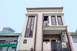 泗水OYO 92435 Sunlo Cozy Home Family Homestay Syariah的窗户上配有电视的建筑