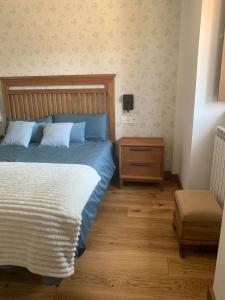 PiluPeta Casa de Aldea的一间卧室配有一张带木制床头板和一张桌子的床。
