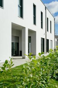 维也纳新城Lamede的白色的房子,有黑色的窗户和绿色的植被