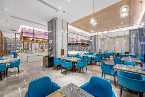 惠州惠州裕华铂金酒店的一间设有蓝色椅子和桌子的餐厅