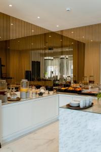 维也纳新城Nava Motel & Storage的一间设有白色柜台和木墙的大厨房