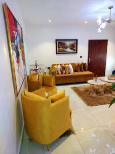 莱基HOMEDALES Freedom Way LEKKI Phase1 LAGOS的客厅配有黄色椅子和沙发