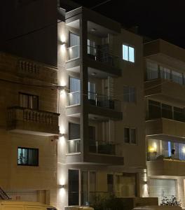Is-SwieqiSkylark 2 Apartment with Terrace的夜晚高高的公寓楼,灯火通明