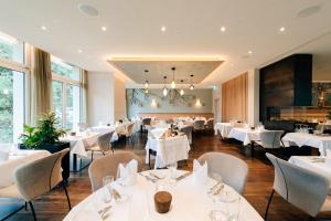温特图尔Park Hotel Winterthur的一间设有白色桌椅的用餐室