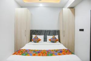 加济阿巴德Hotel The RASA at Vasundhara的卧室配有一张带彩色枕头的大型白色床。