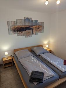 加兹尤瑟多姆Ferienwohnung Am Kleinen Haff的一间卧室设有两张床,墙上挂着一幅画