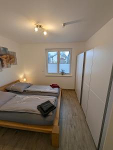 加兹尤瑟多姆Ferienwohnung Am Kleinen Haff的一间卧室设有一张床和一个窗口