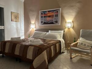 塔兰托Artemide Home的一间卧室配有一张带两盏灯和一把椅子的床。