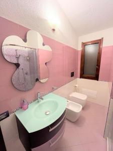 杰若米斯Villa Fiorilla的粉红色的浴室设有苹果形水槽和卫生间